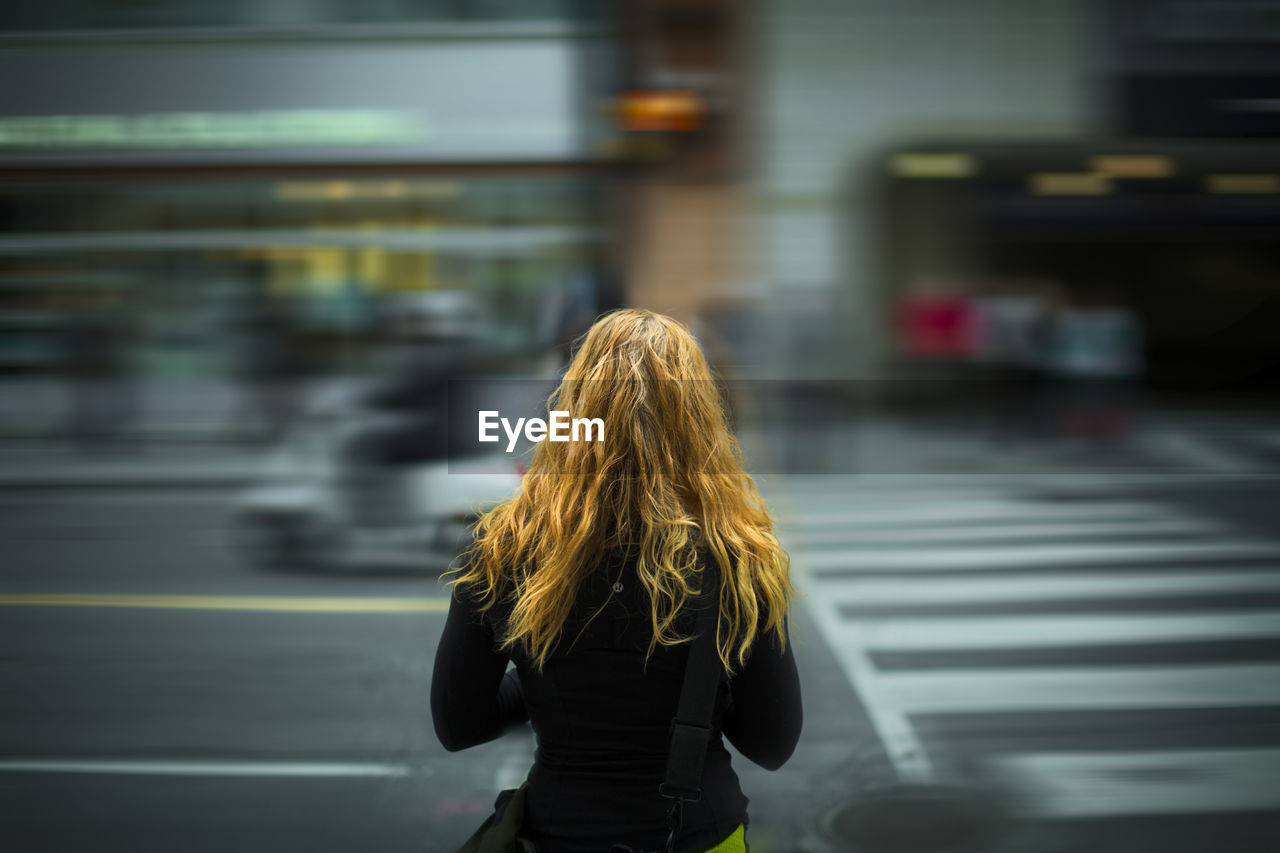 REAR VIEW OF WOMAN STANDING AT BUS