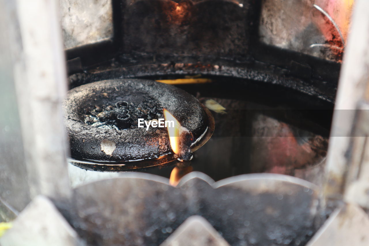 High angle view of lit candles on metal