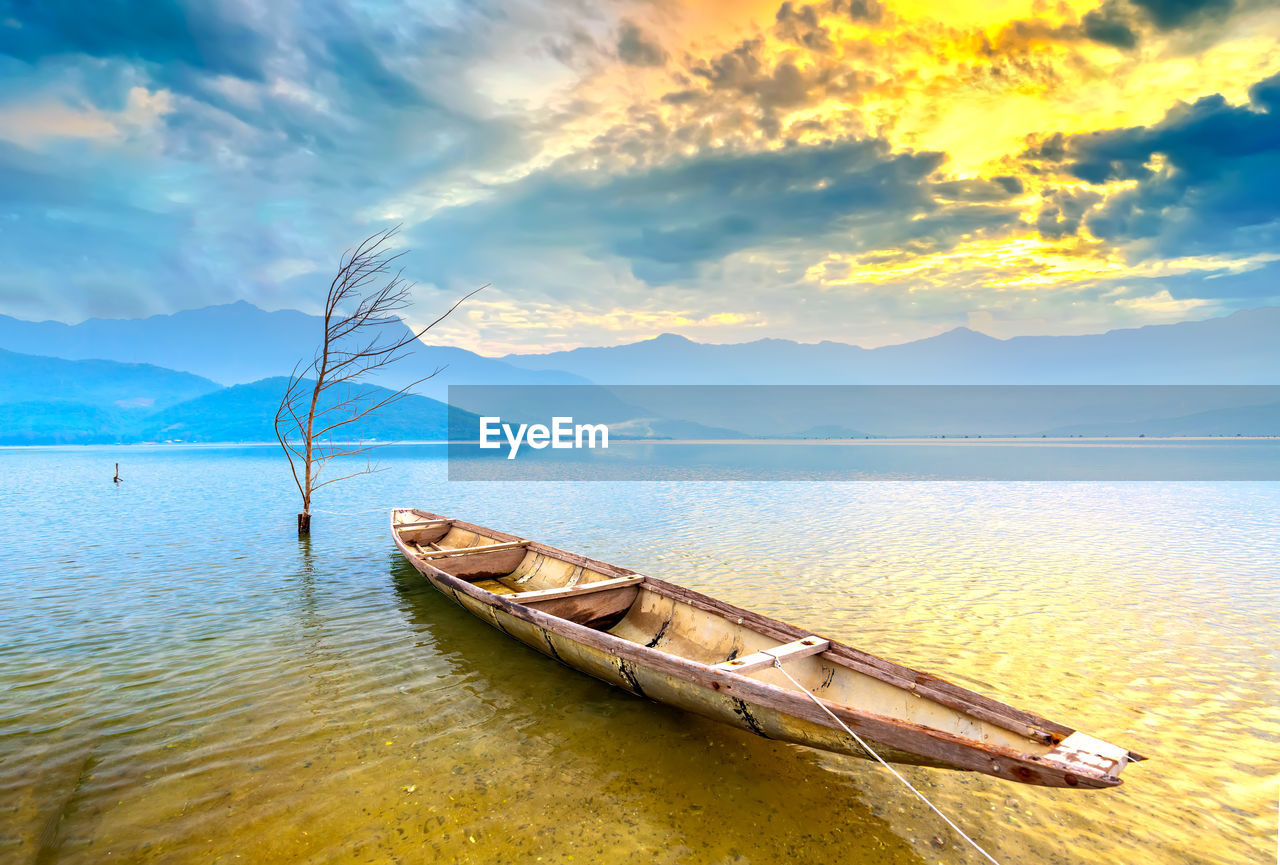 BOAT MOORED AT SEA AGAINST SKY