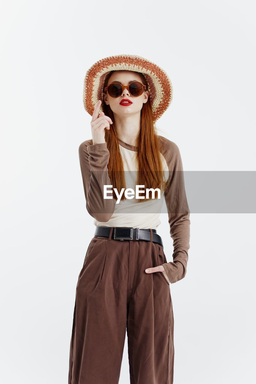 brown, adult, clothing, one person, women, fashion, hat, studio shot, portrait, young adult, fashion accessory, standing, three quarter length, indoors, copy space, sun hat, female, person, human face, outerwear, white background, hairstyle, front view, looking at camera, photo shoot, spring, long hair, sleeve, maroon, sunglasses, collar, glasses, casual clothing, trousers, cut out, emotion, looking, relaxation, pattern, blond hair