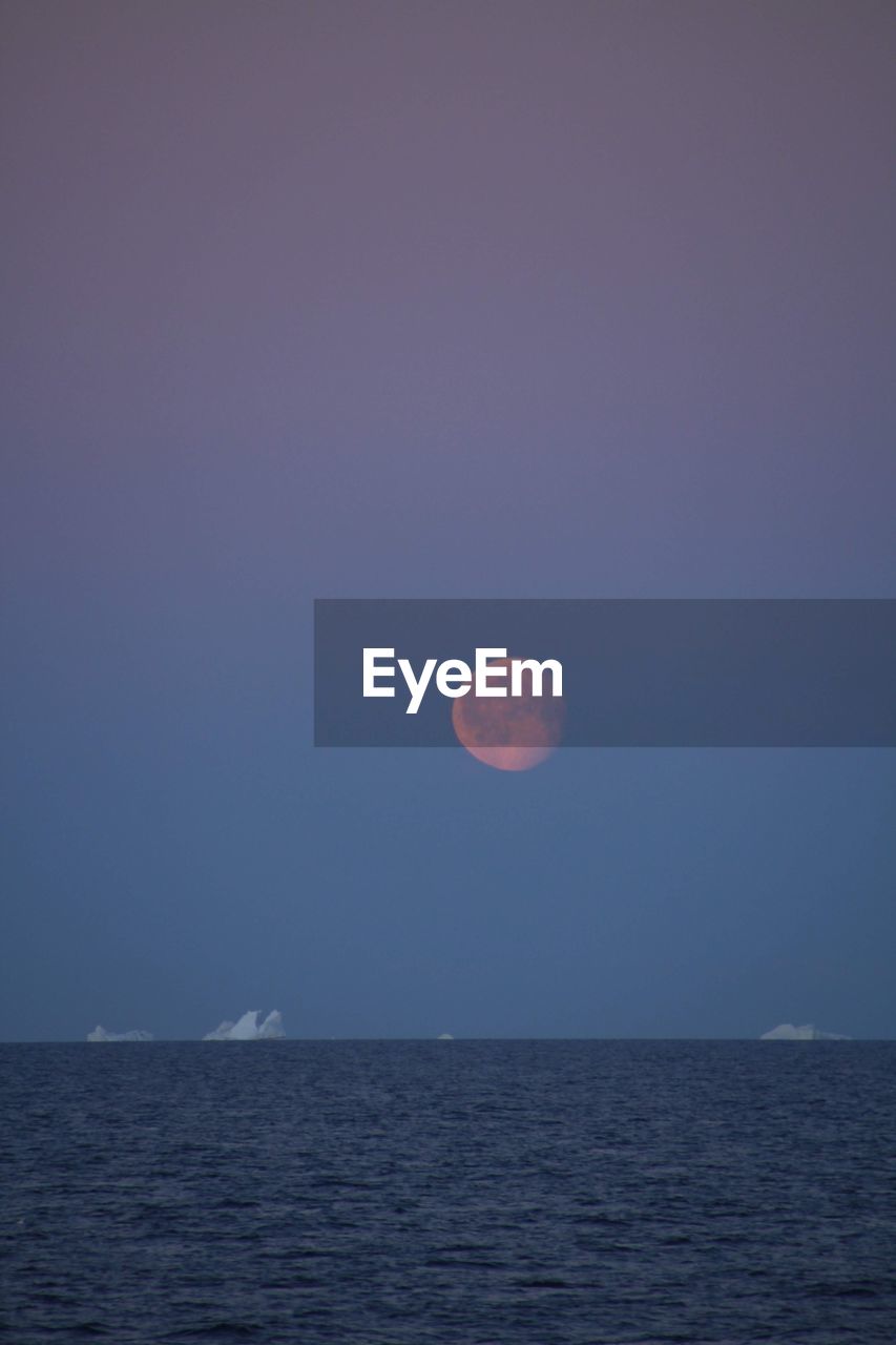 SCENIC VIEW OF SEA AGAINST CLEAR SKY AT DUSK