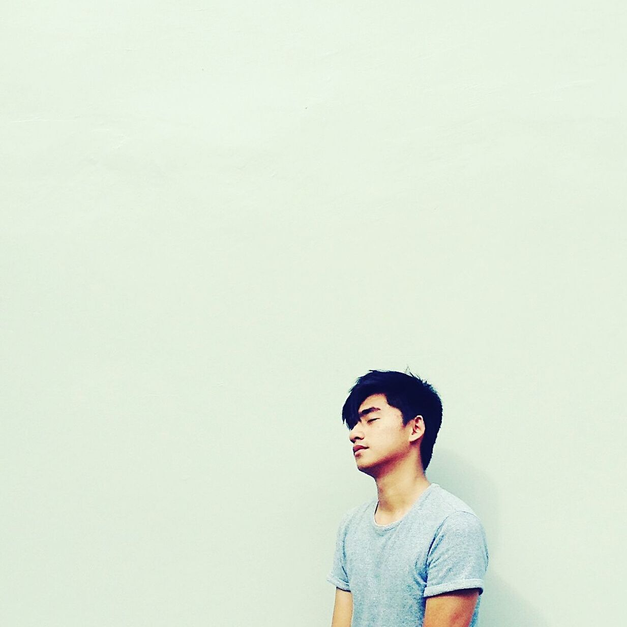 Young man leaning on wall