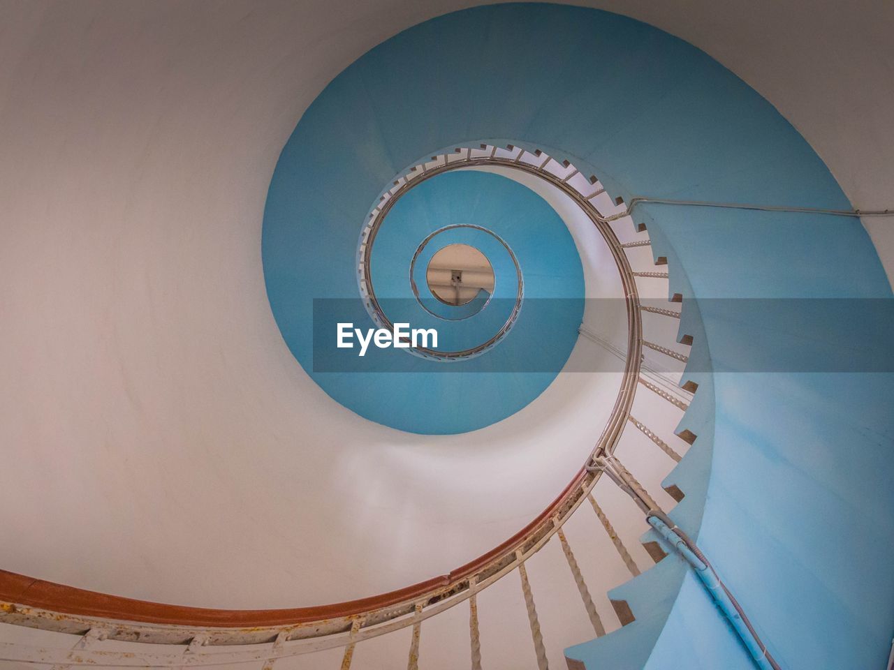 DIRECTLY BELOW SHOT OF SPIRAL STAIRCASE IN BUILDING
