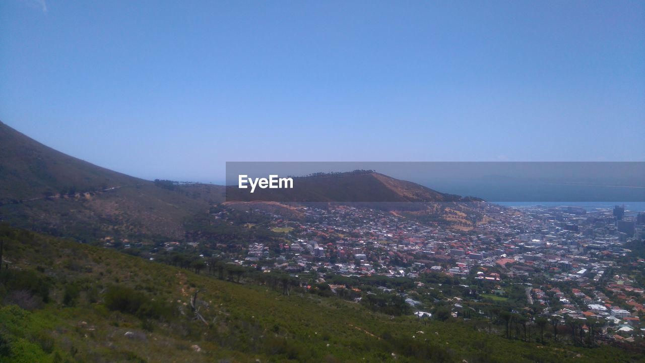 SCENIC VIEW OF FIELD AND MOUNTAINS AGAINST CLEAR BLUE SKY