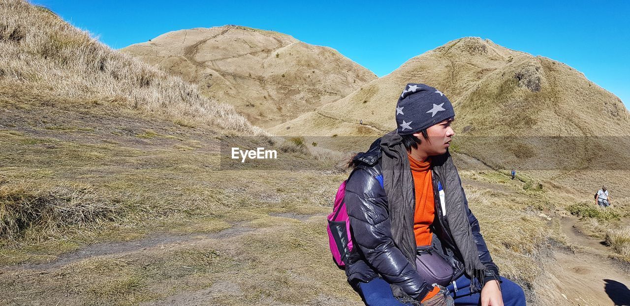 BOY STANDING ON MOUNTAIN