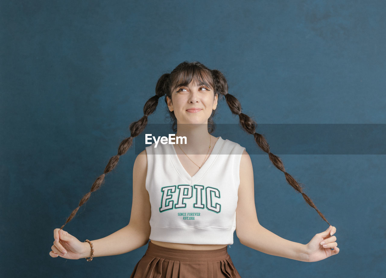 Young woman playing with plaits