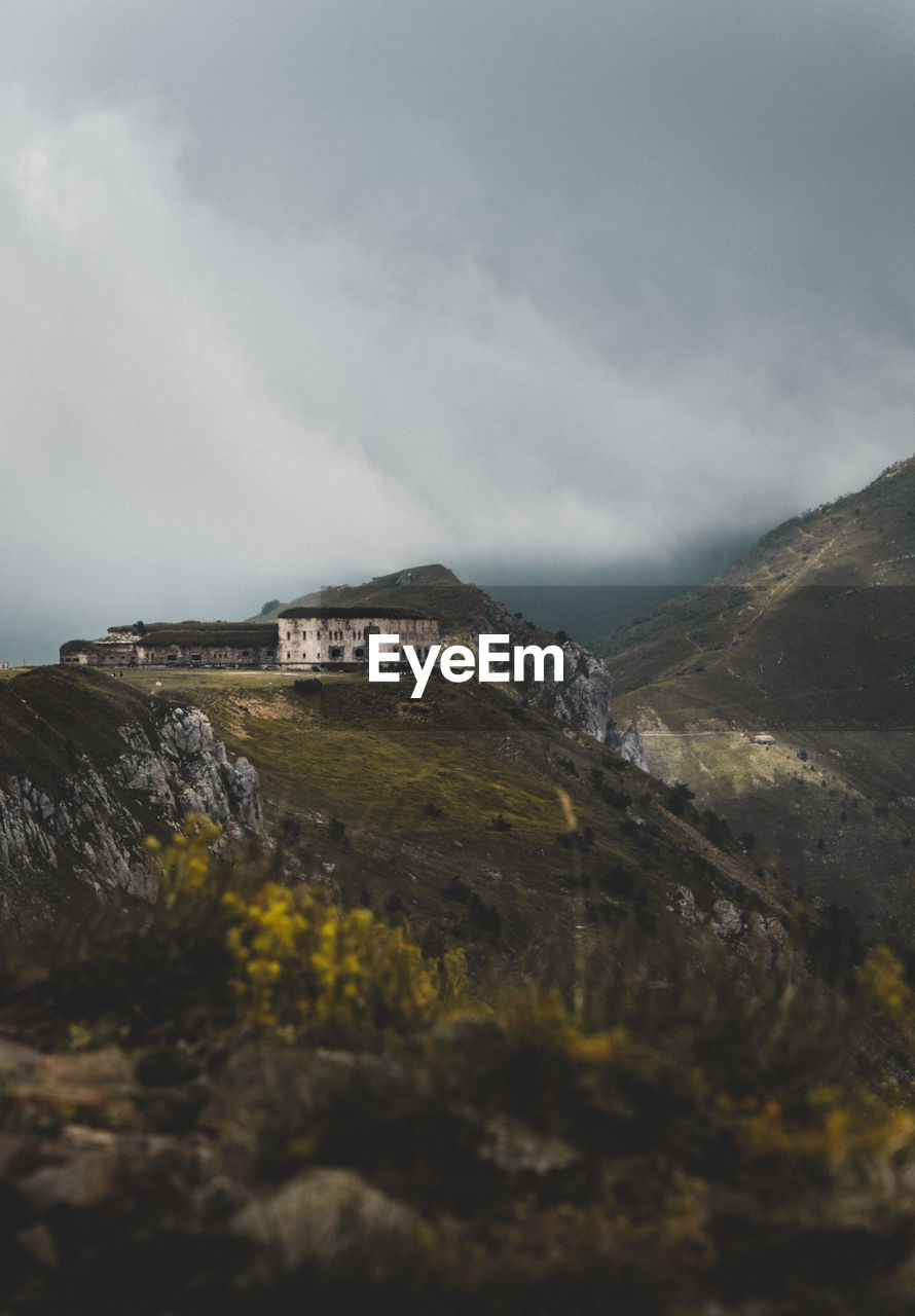 Scenic view of mountains against cloudy sky