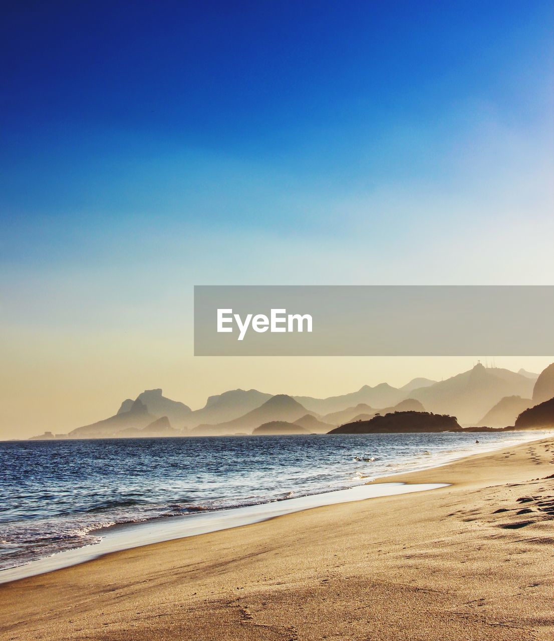 Scenic view of beach against clear blue sky