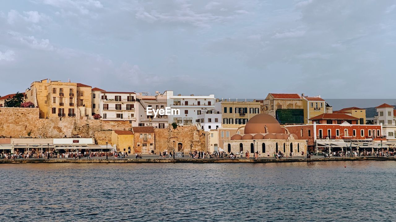 buildings by sea against sky