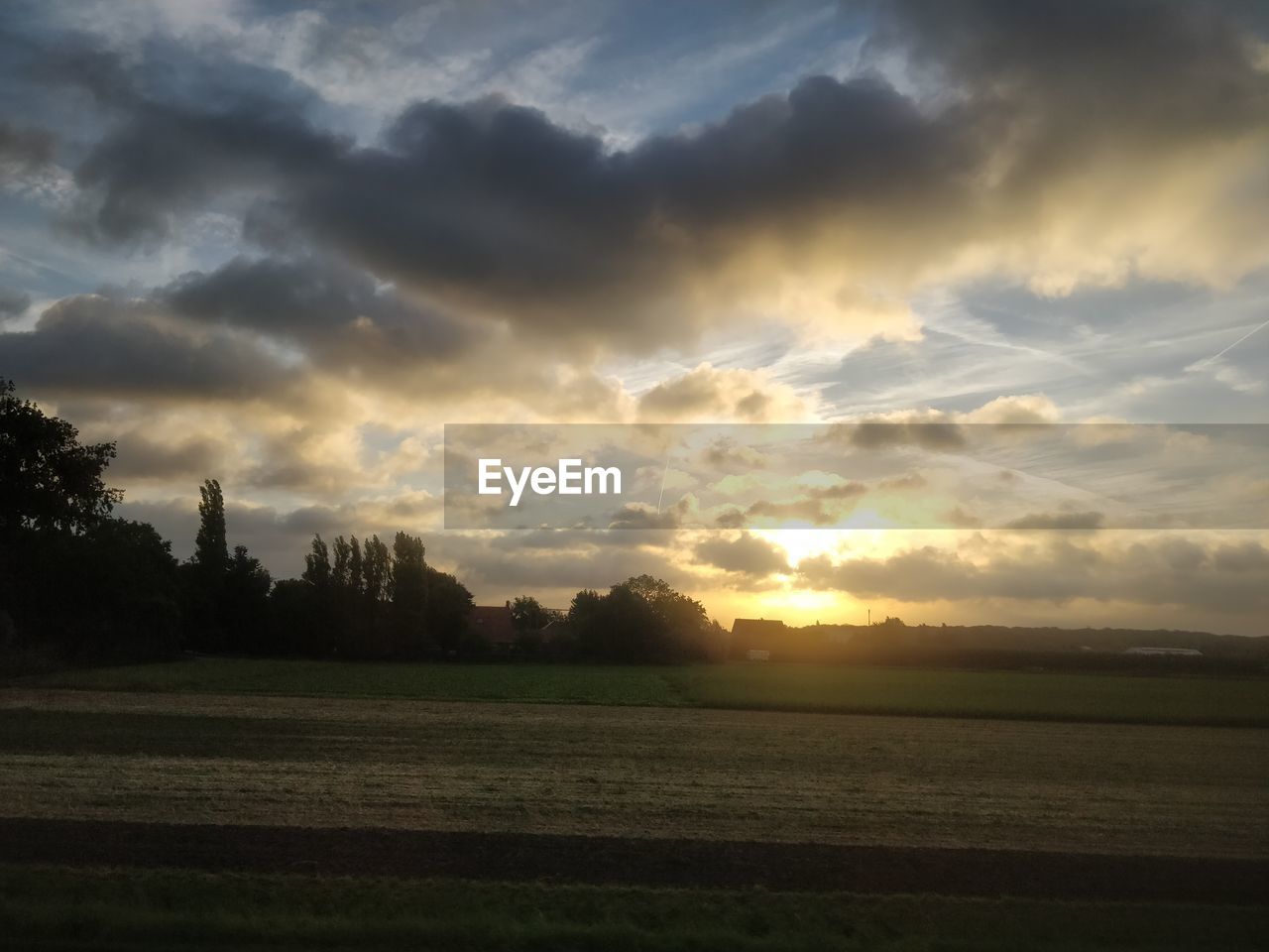 SCENIC VIEW OF FIELD AGAINST CLOUDY SKY DURING SUNSET