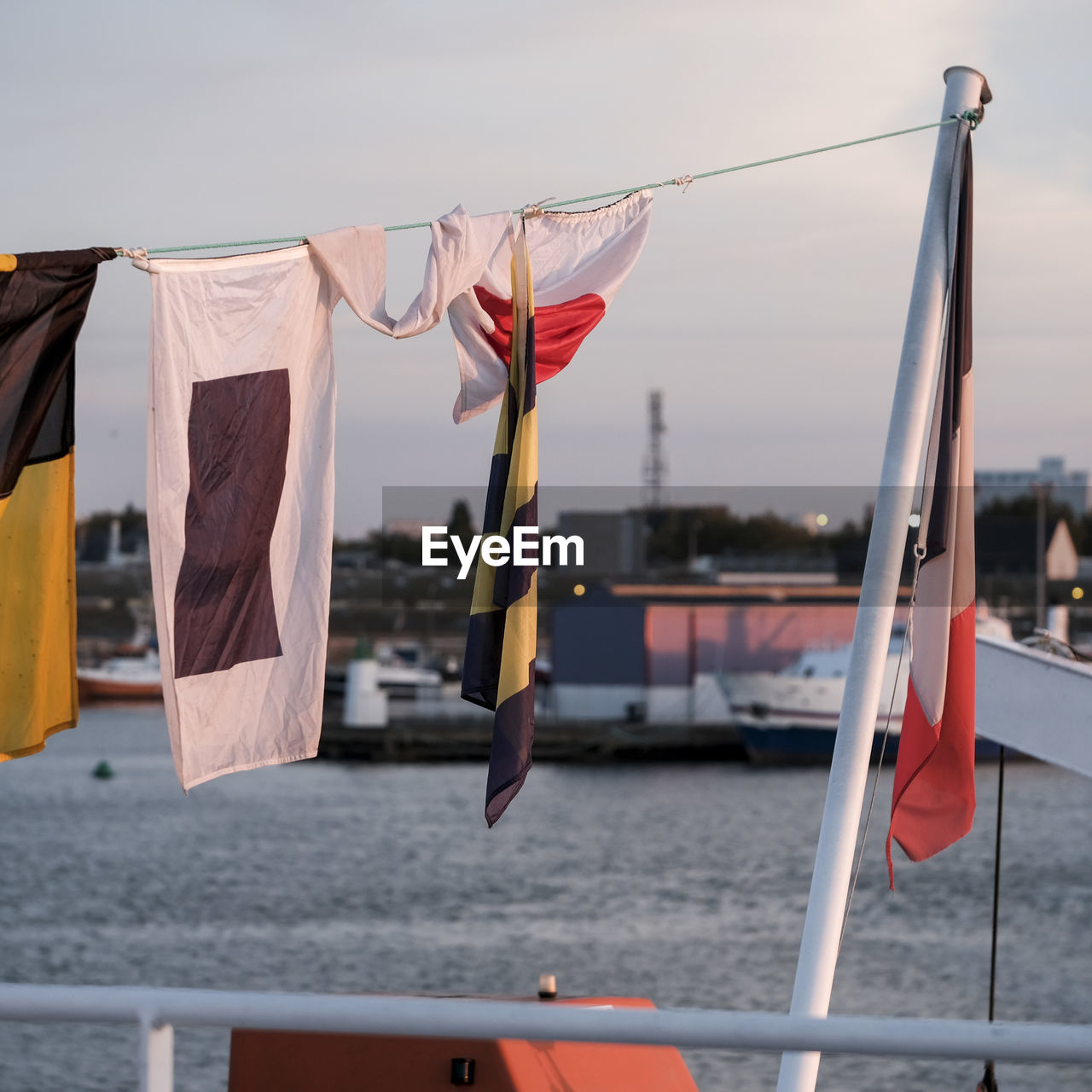 CLOSE-UP OF FLAGS HANGING ON BOAT