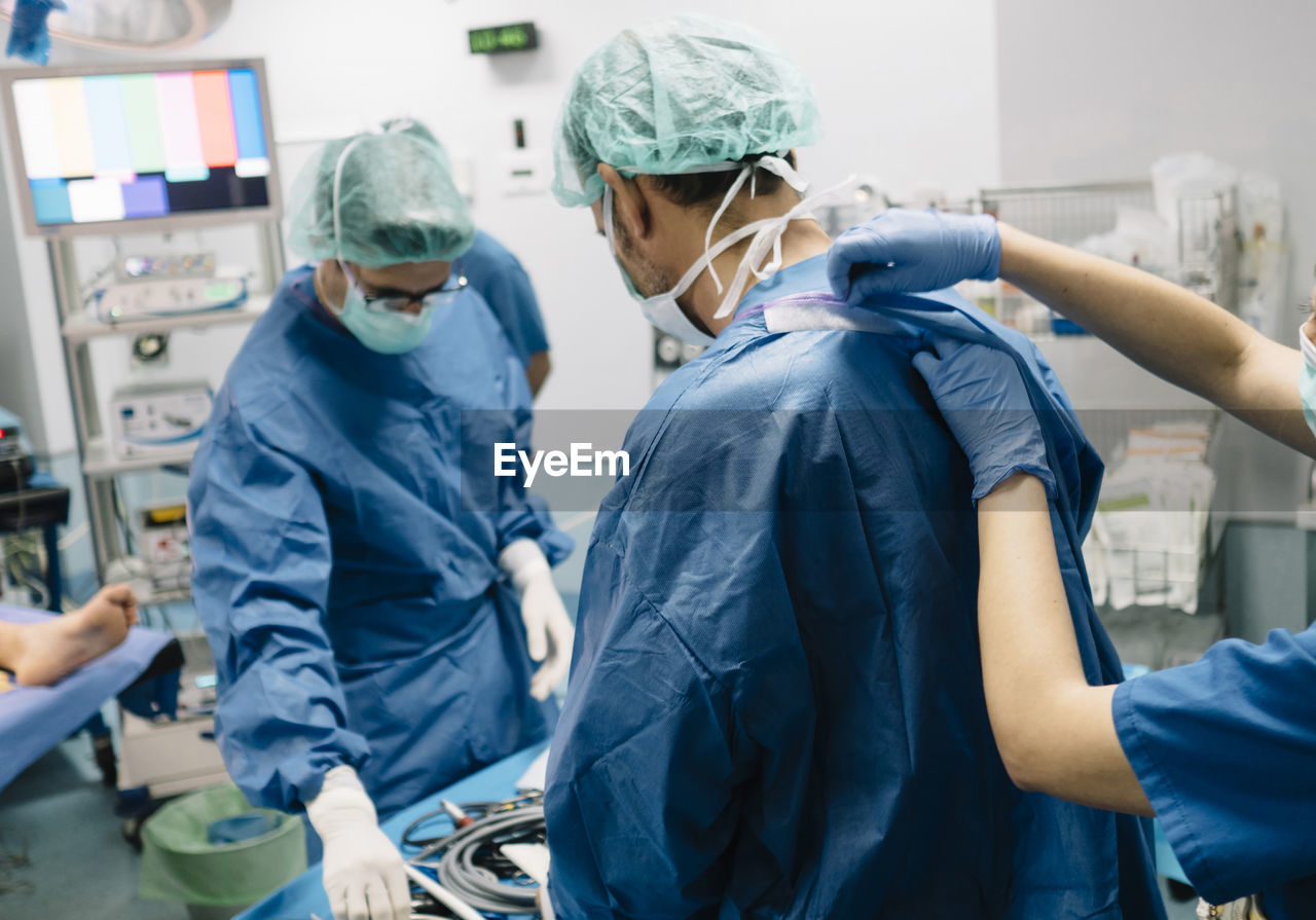 Female doctor helping orthopedic surgeon in operating room at hospital