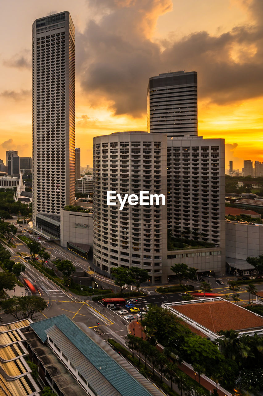 Modern buildings in city against sky during sunset