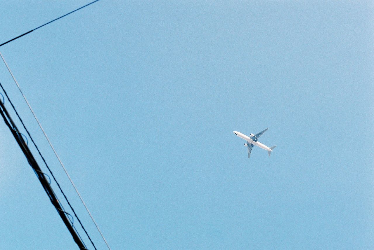 Low angle view of airplane flying against clear sky
