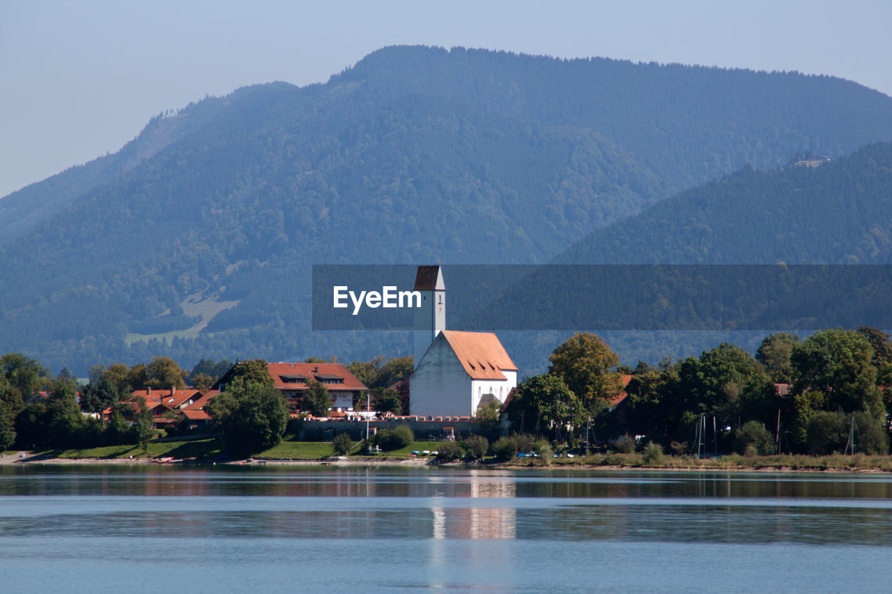 Scenic view of lake by buildings against sky