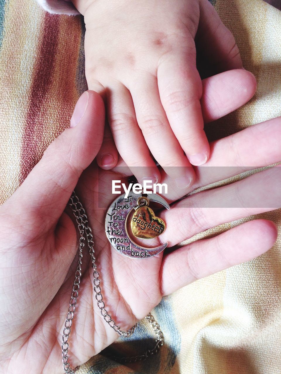 Cropped image of mother and daughter with pendant