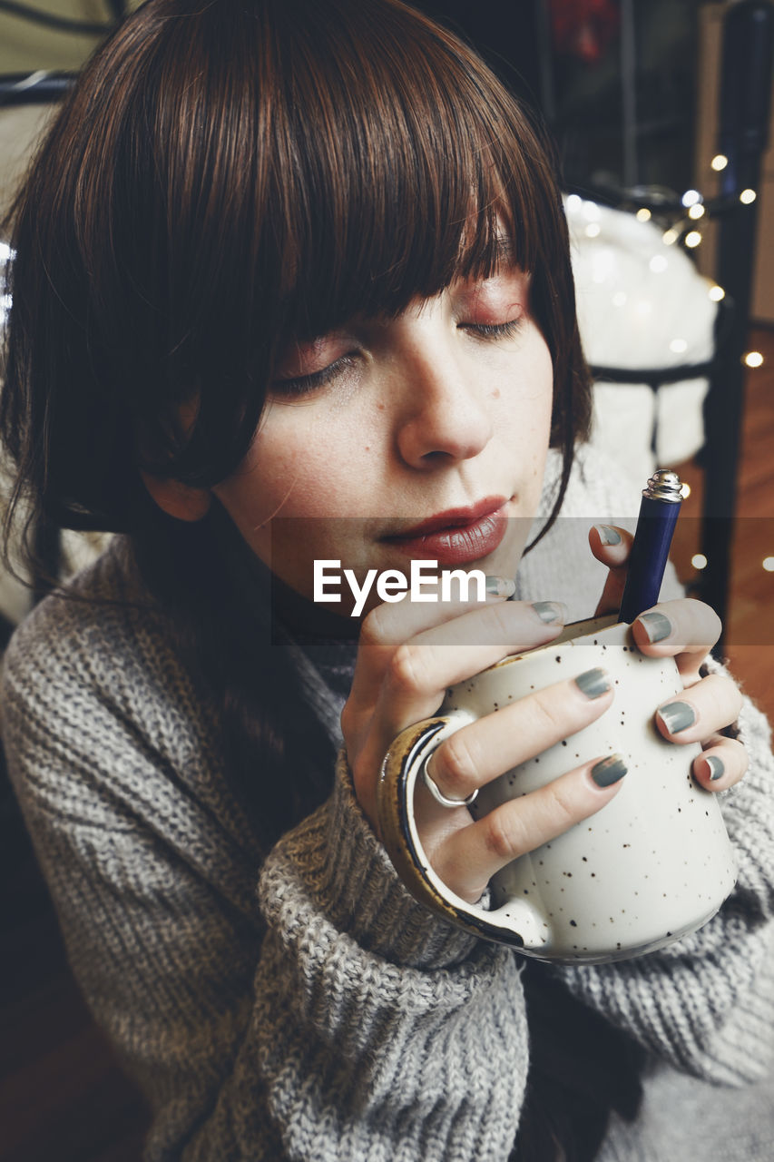 Portrait of young woman drinking coffee