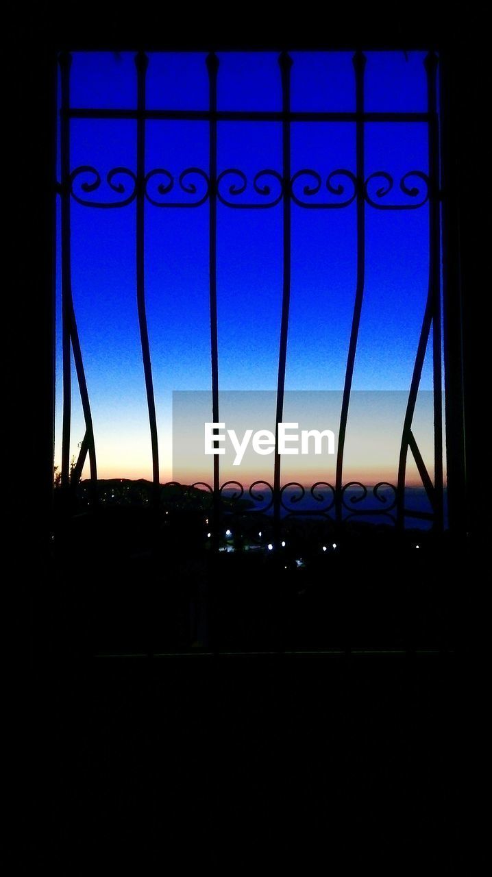 SILHOUETTE OF BUILT STRUCTURES AGAINST SKY AT SUNSET