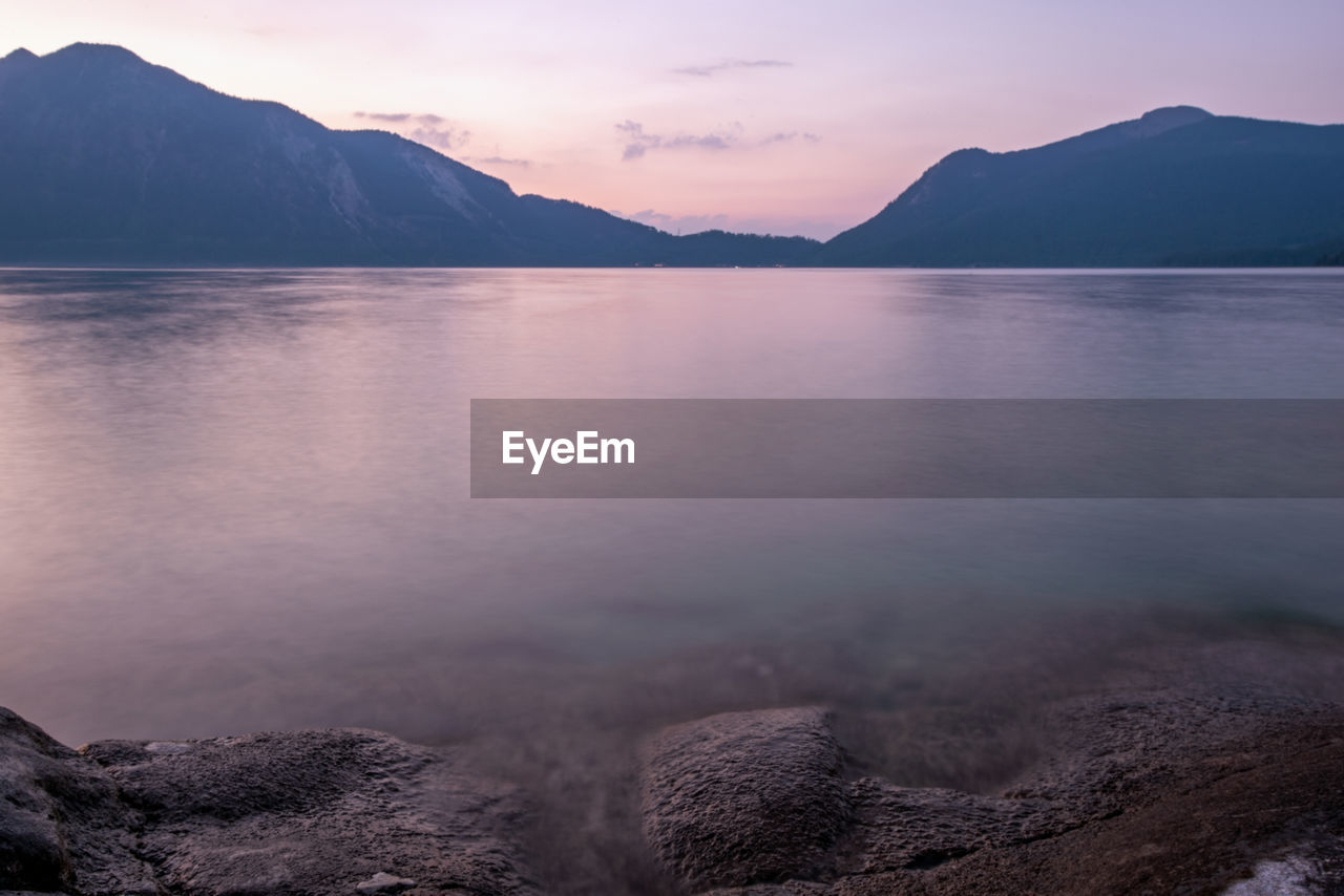 scenic view of lake and mountains against sky during sunset