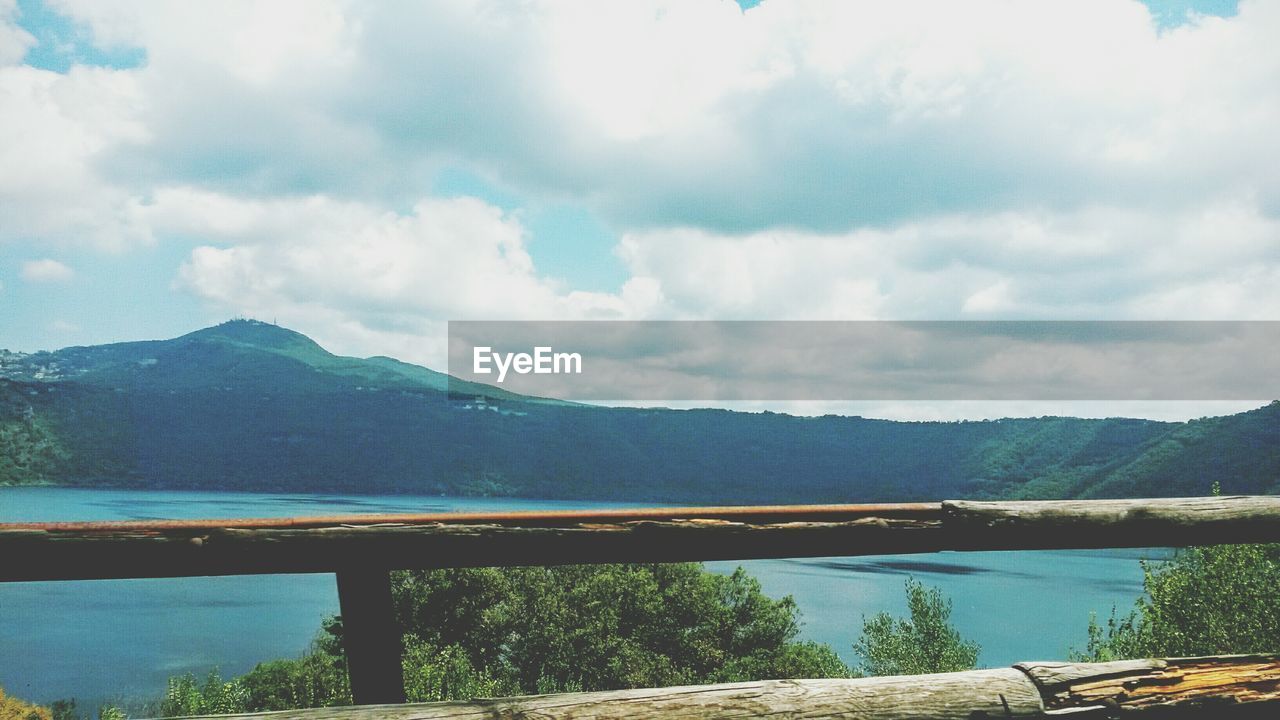 Scenic view of lake and mountains against cloudy sky