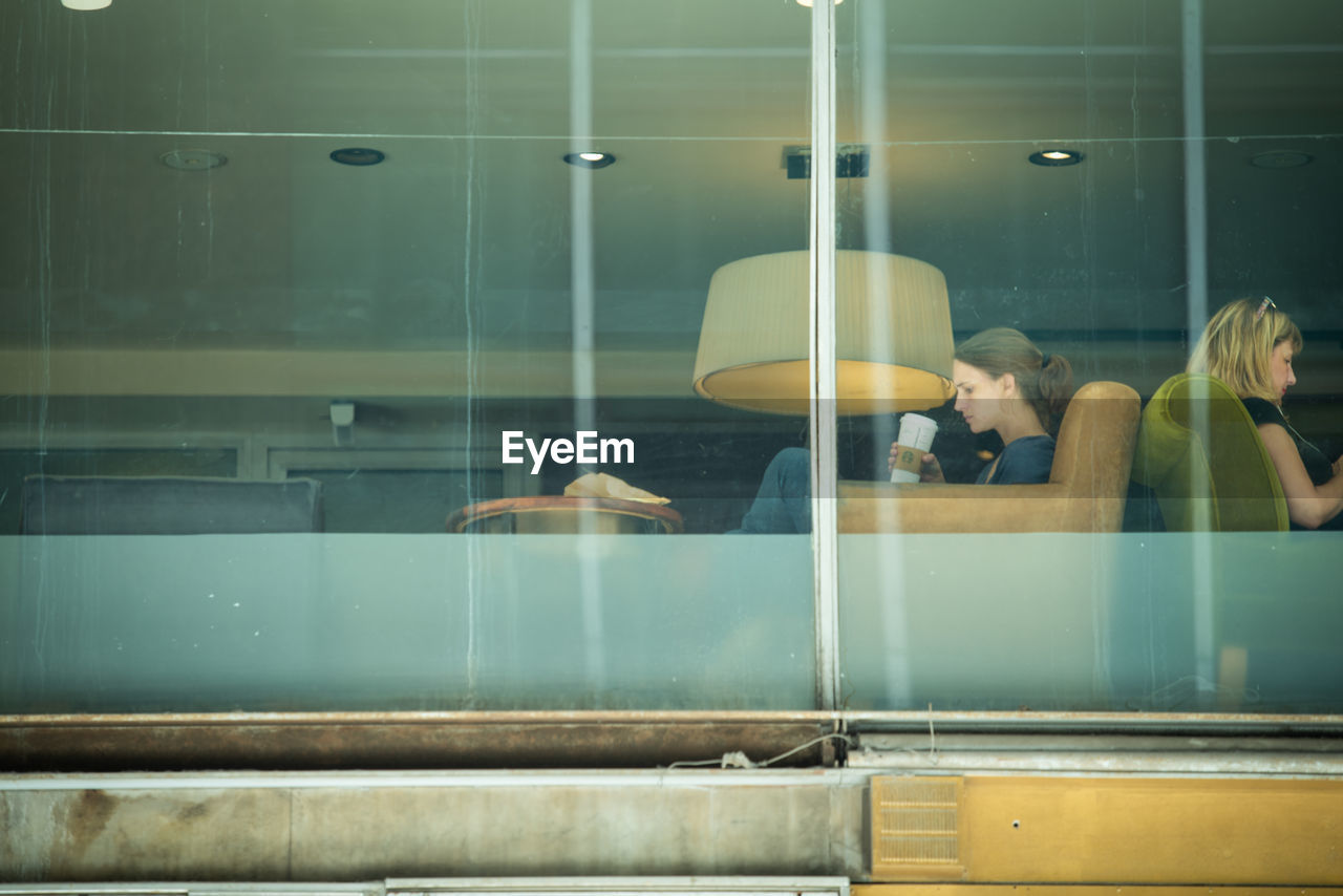 PEOPLE LOOKING THROUGH WINDOW AT BUS