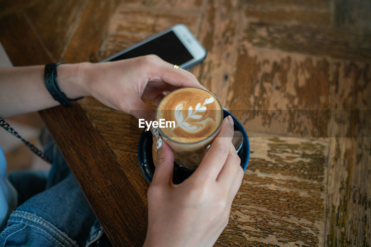 Woman holding coffee cup at table