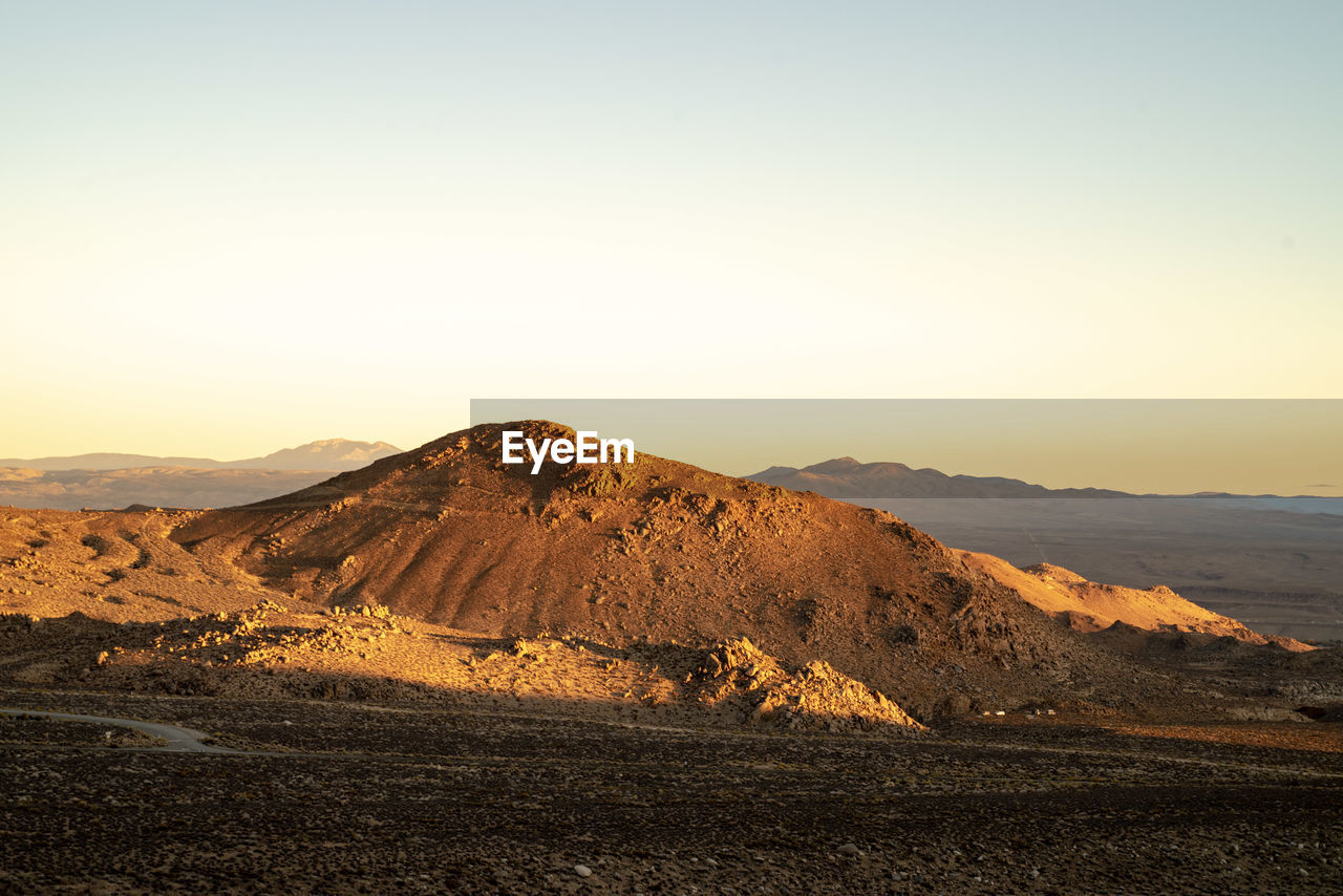 Scenic view of mountains against clear sky during sunset