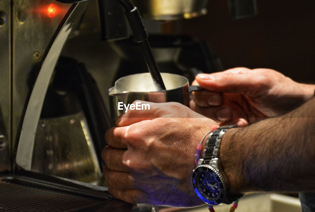 Midsection of man having coffee in kitchen