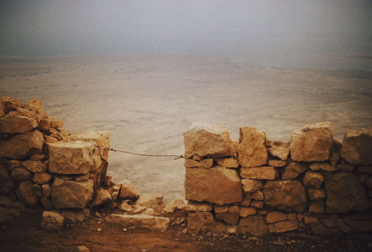 Ruined wall of ancient masada fortress in desert near dead sea