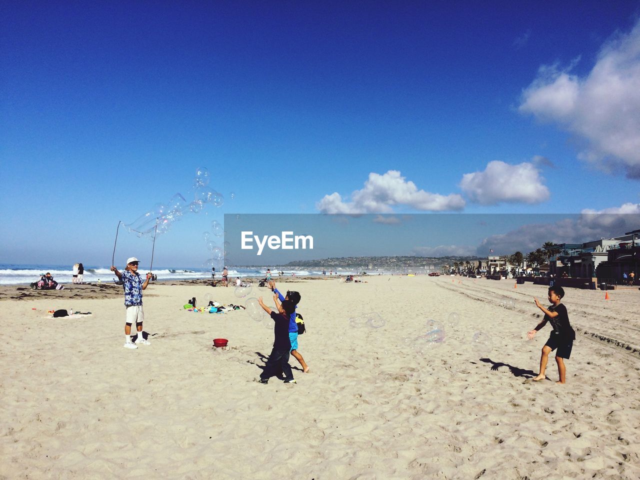 PEOPLE ON BEACH AGAINST SKY