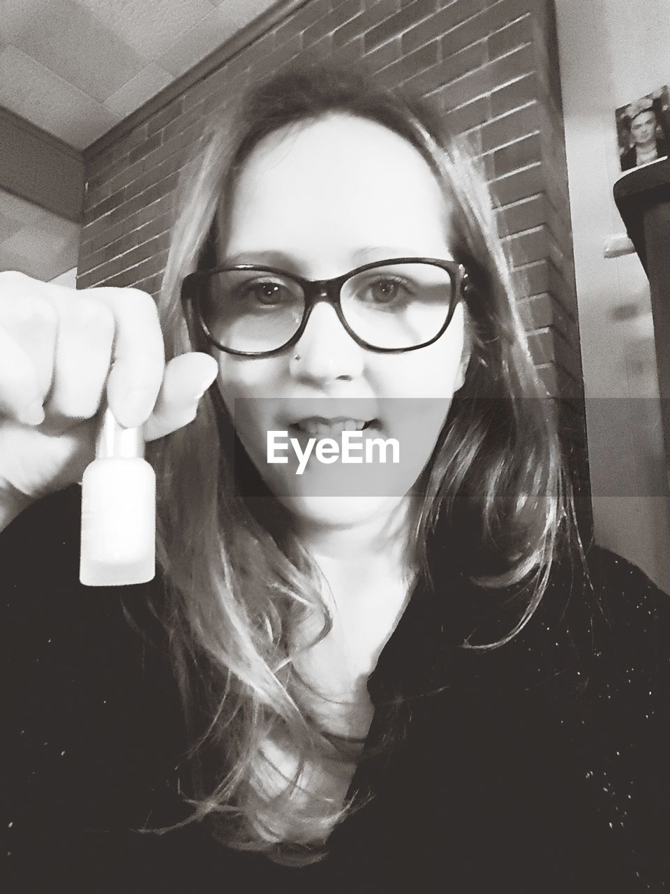 PORTRAIT OF A SMILING YOUNG WOMAN WITH EYEGLASSES