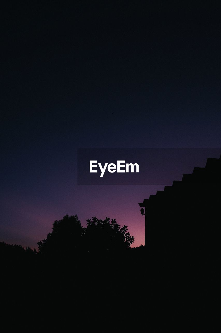 Low angle view of silhouette building against sky at night