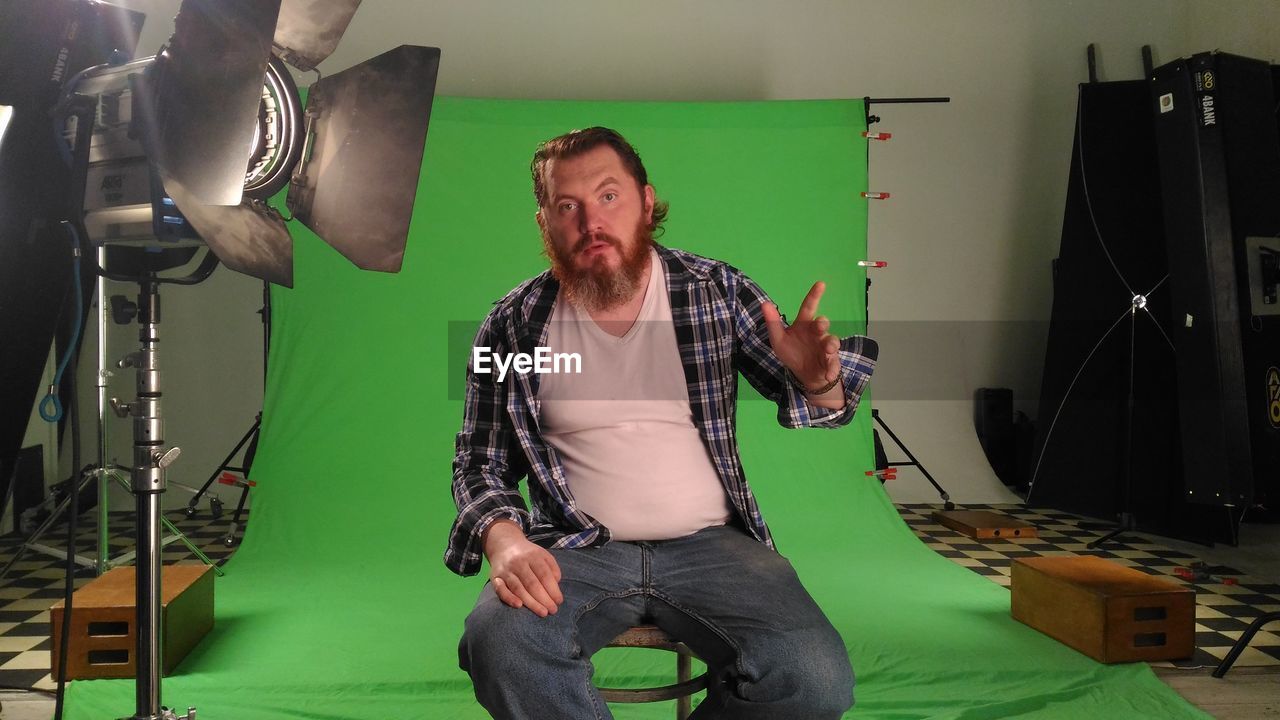 Portrait of man on seat in film studio