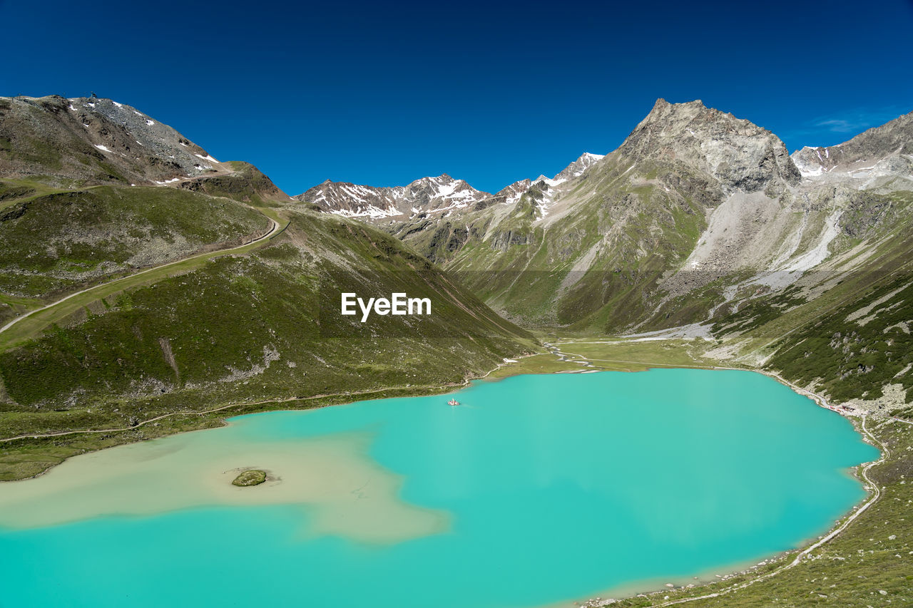 SCENIC VIEW OF LAKE BY MOUNTAIN AGAINST BLUE SKY