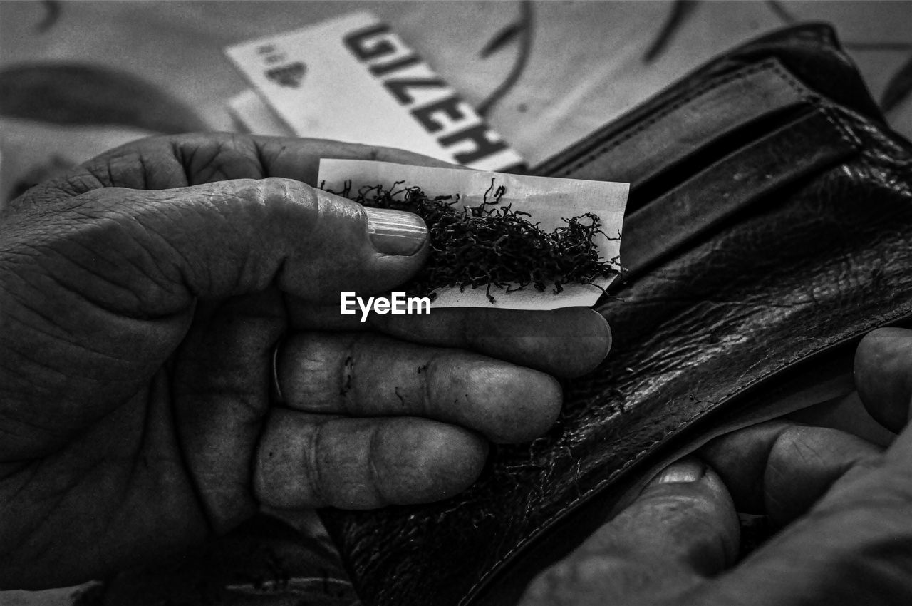 Close-up of hand holding cigarette