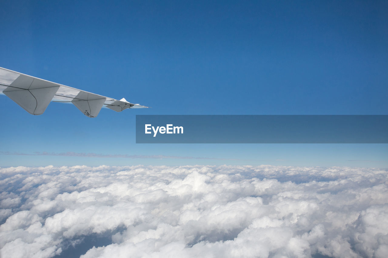 Cropped image of aircraft wing flying in sky