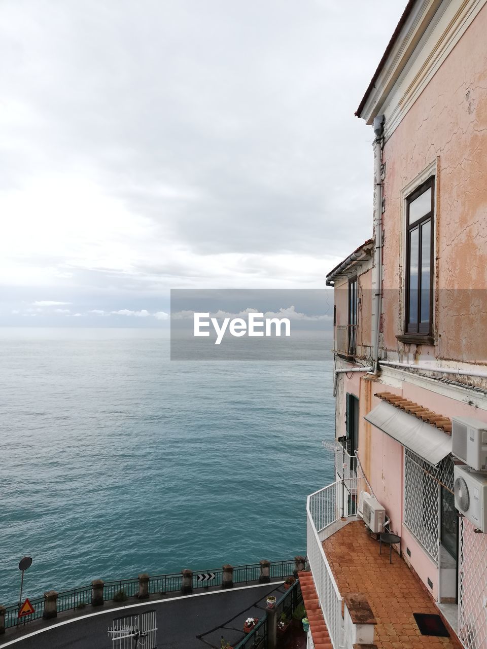 Buildings by sea against sky