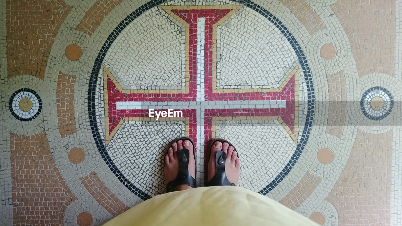 Directly above shot of womans standing on cross symbol