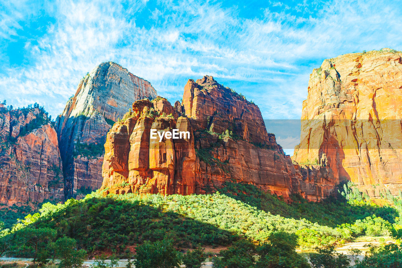 rock, rock formation, scenics - nature, travel destinations, beauty in nature, nature, sky, landscape, environment, national park, travel, land, park, mountain, non-urban scene, cloud, no people, geology, canyon, tranquility, tourism, tranquil scene, plant, outdoors, cliff, mountain range, day, valley, blue, panoramic, idyllic, physical geography, sunlight, multi colored, tree, formation, extreme terrain, eroded, rocky mountains