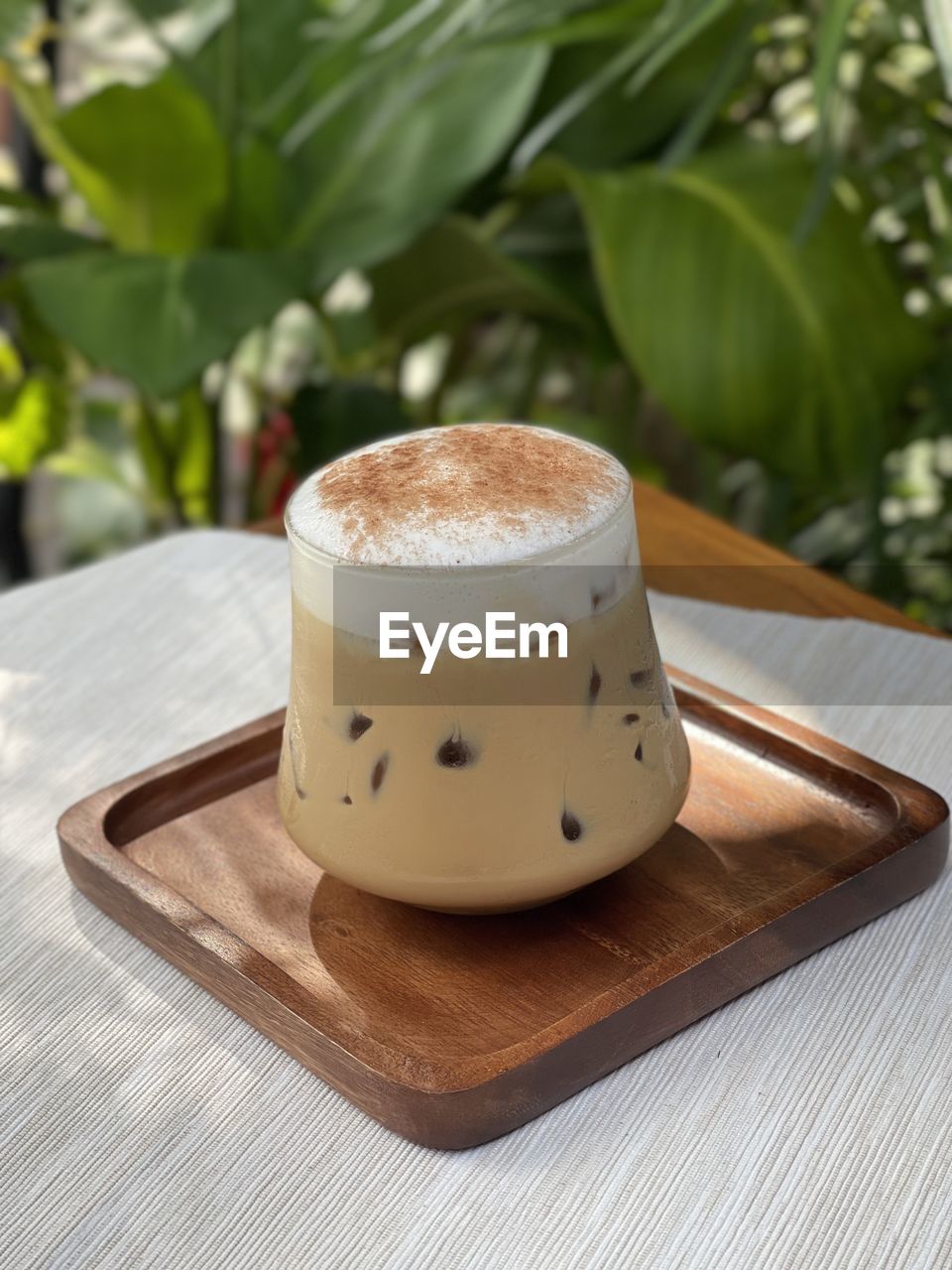 CLOSE-UP OF COFFEE CUP ON TABLE AGAINST BLURRED BACKGROUND