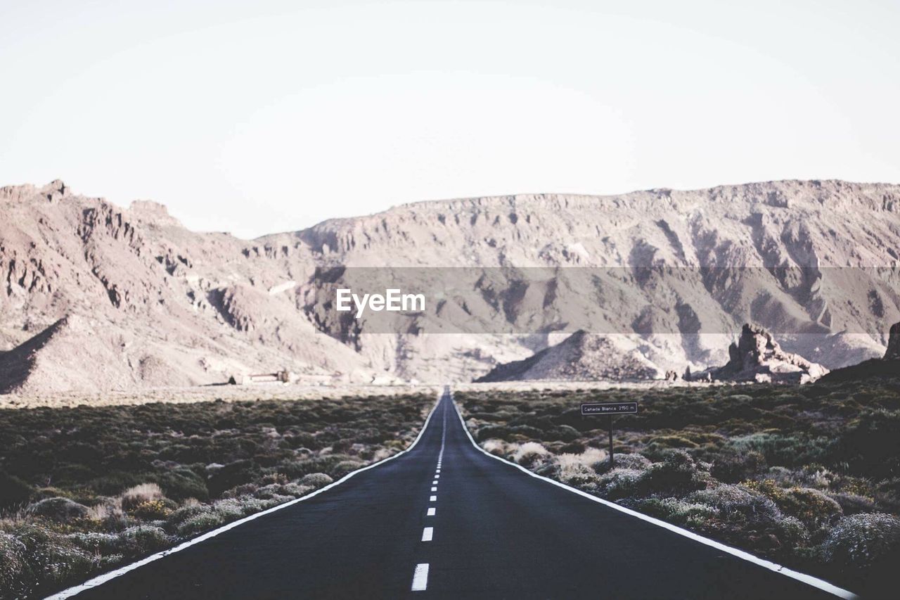 Empty road leading towards mountains