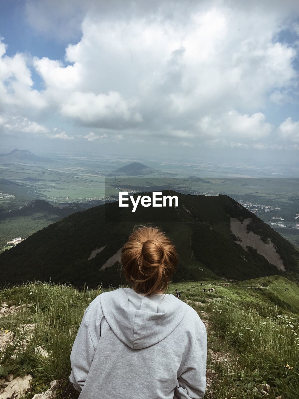 Rear view of woman on mountain against cloudy sky