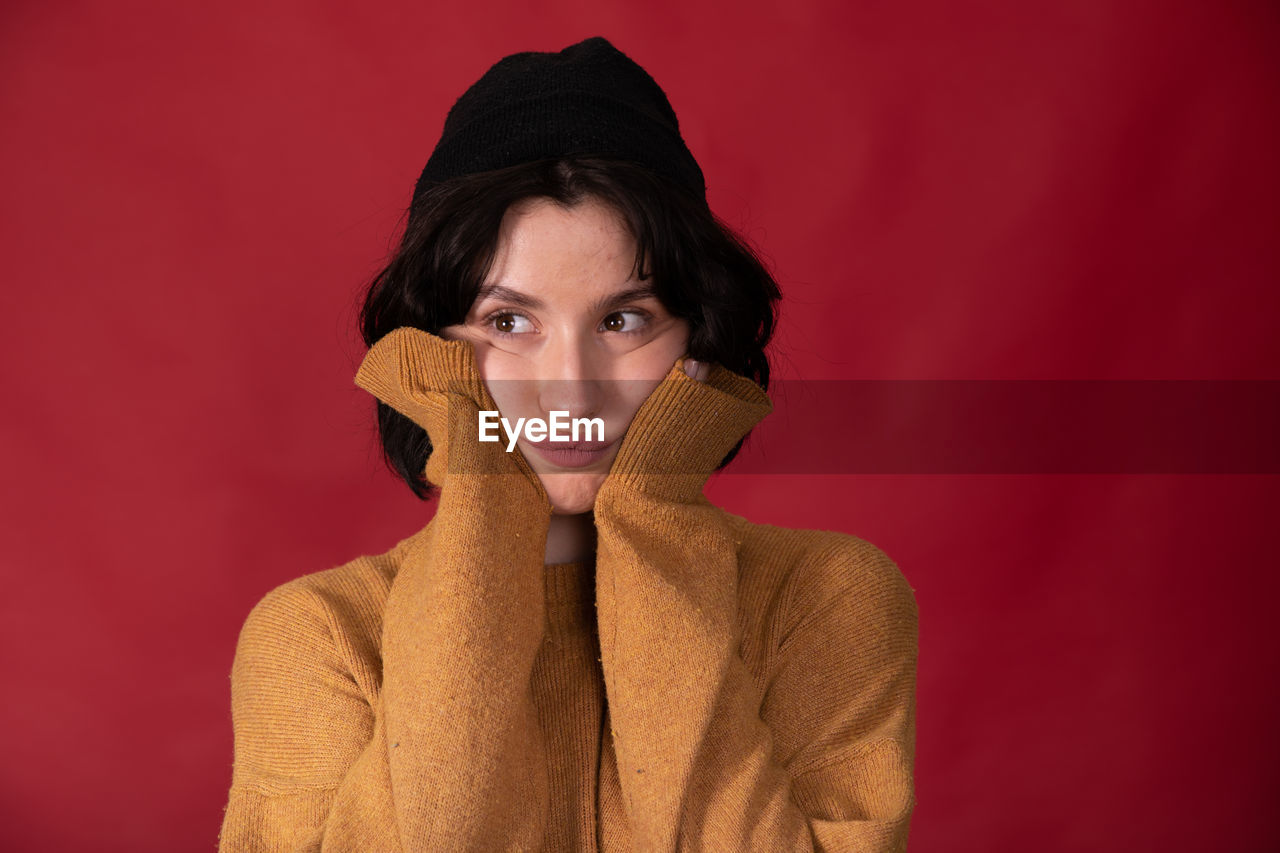 PORTRAIT OF WOMAN WITH RED FACE AGAINST COLORED BACKGROUND