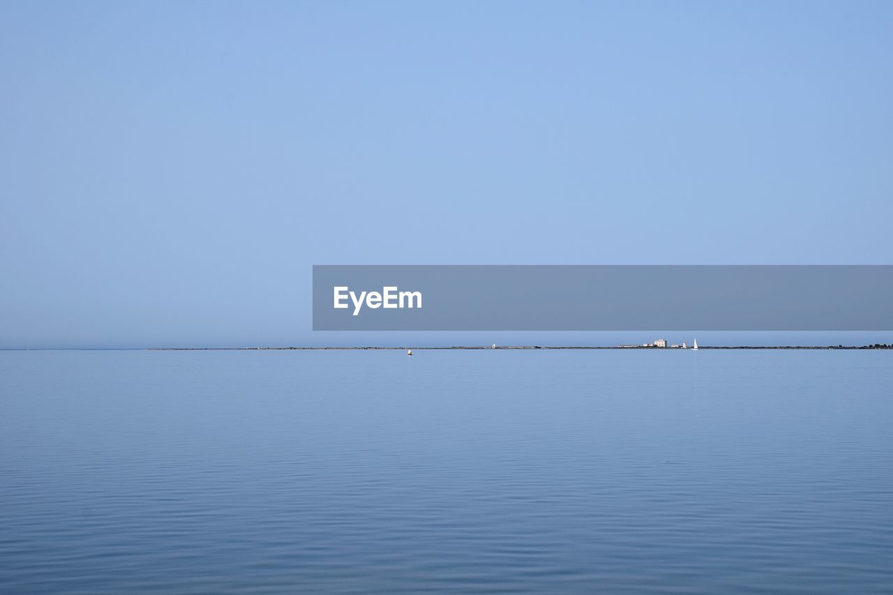 Scenic view of sea against clear blue sky