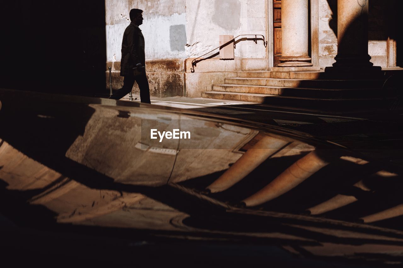 Side view of man walking on staircase