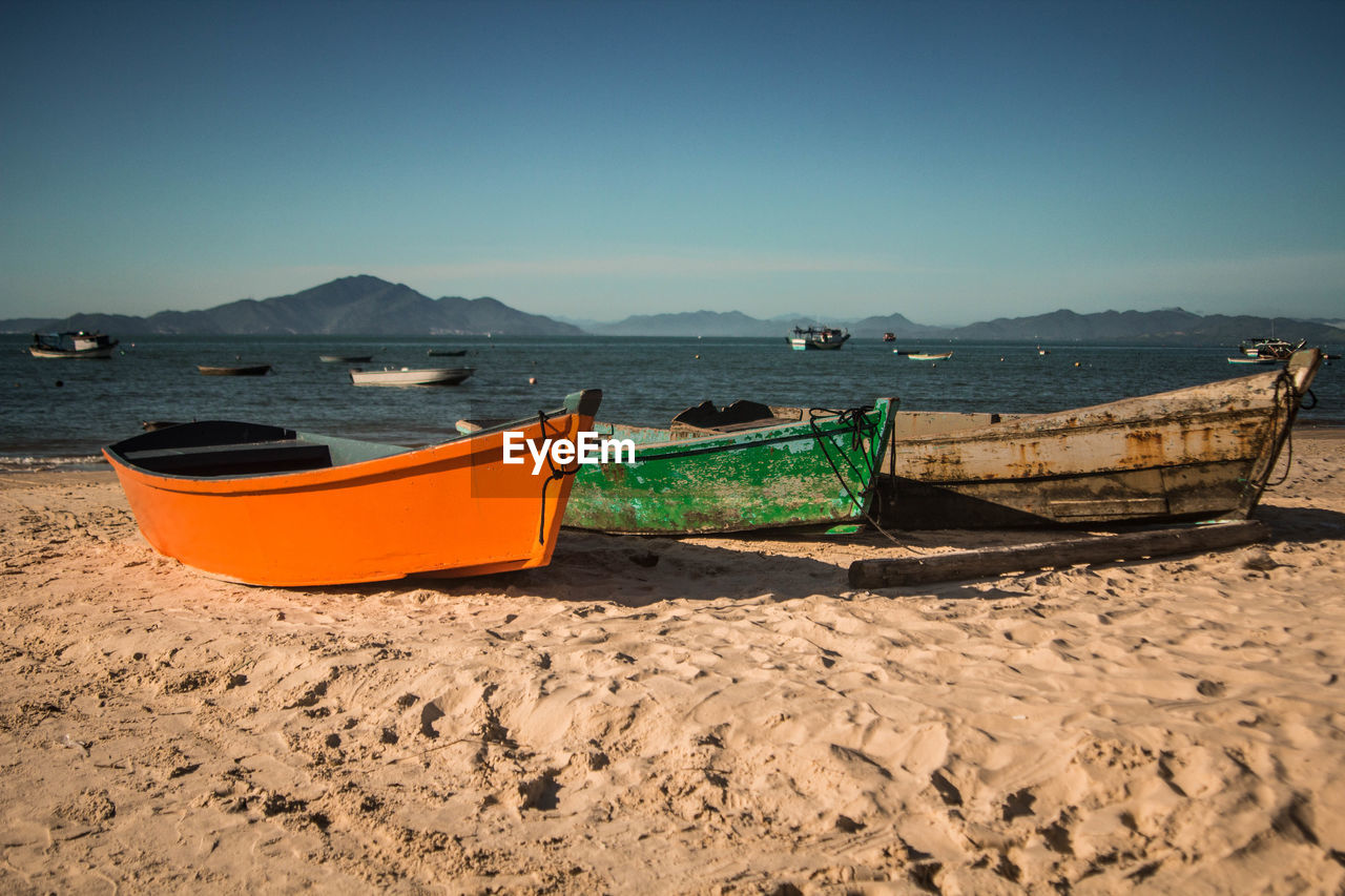 Boats moored at sandy beach