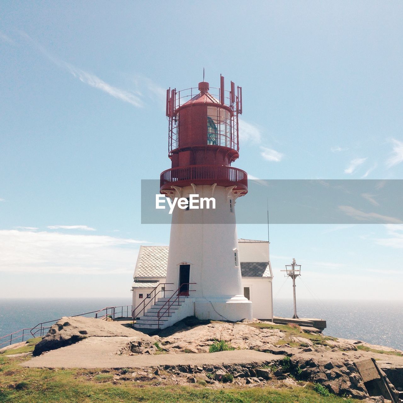 Lighthouse by sea against sky