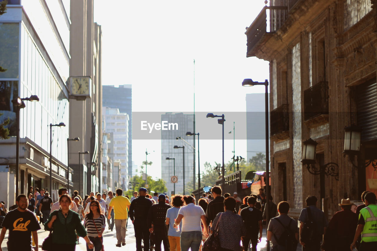 People walking on city street amidst buildings