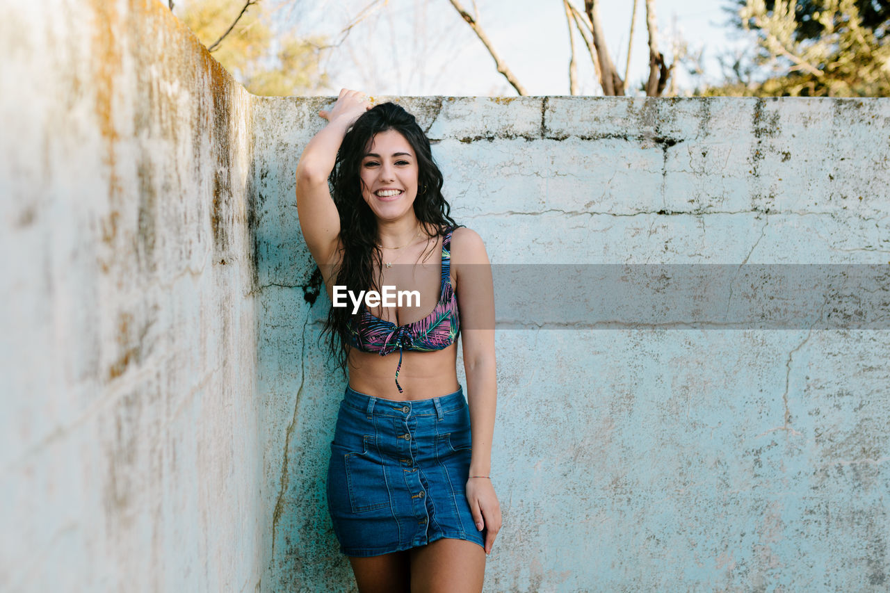 Portrait of beautiful woman standing at abandoned swimming pool