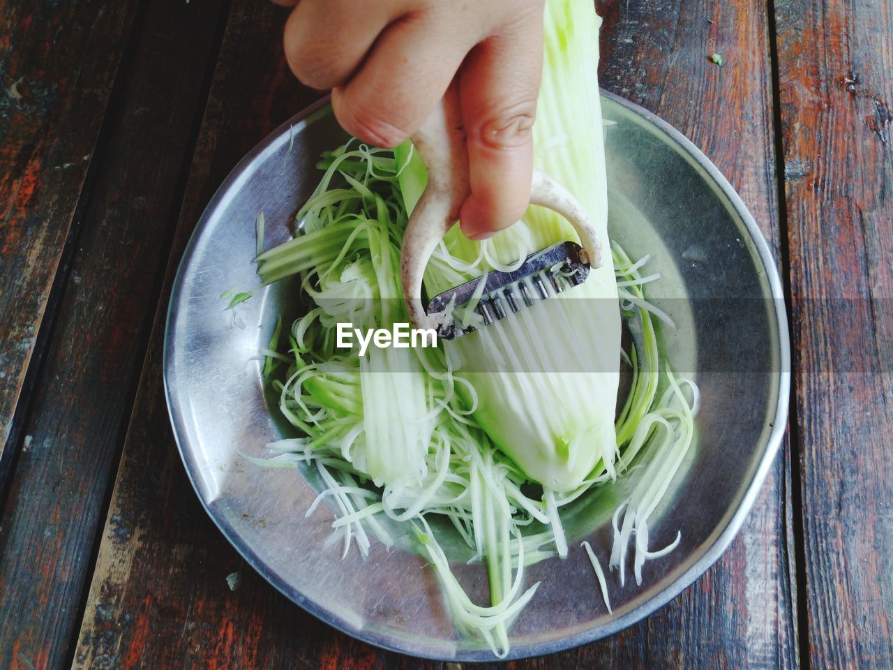 HIGH ANGLE VIEW OF PERSON PREPARING FOOD IN PLATE